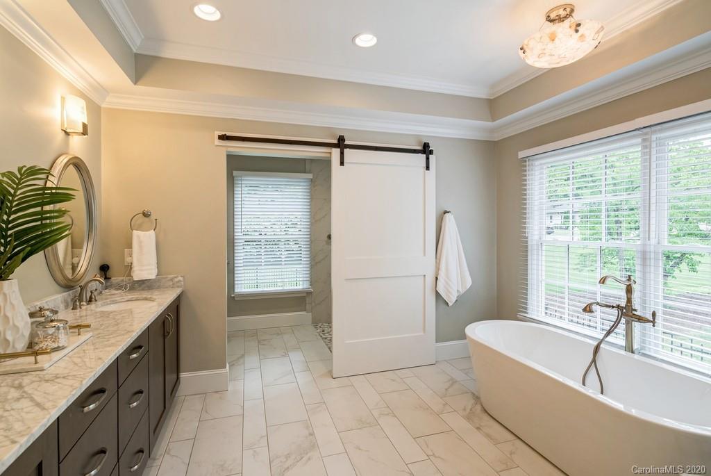 4200 Chelmsford Road Charlotte, NC 28211 - Photo 17 of 45 a spacious bathroom with a tub sink and mirror