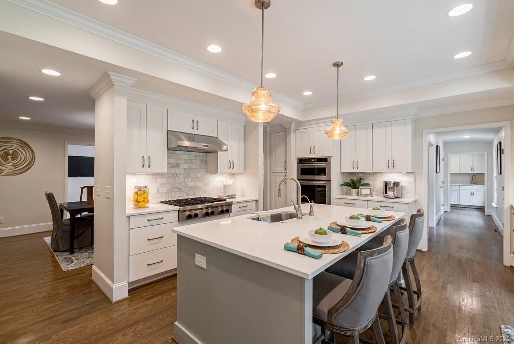4200 Chelmsford Road Charlotte, NC 28211 - Photo 5 of 45 a kitchen that has a lot of cabinets a sink stainless steel appliances and wooden floor