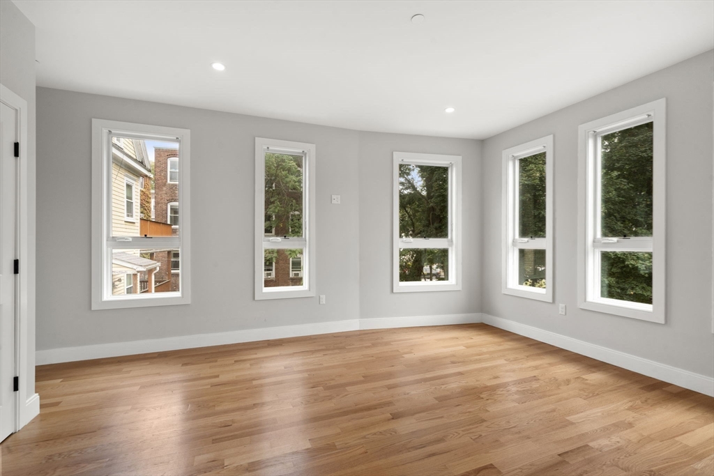 123-125 Centre Street, Unit TH7 Boston, MA 02124 - Photo 11 of 37 a view of an empty room with wooden floor and a window