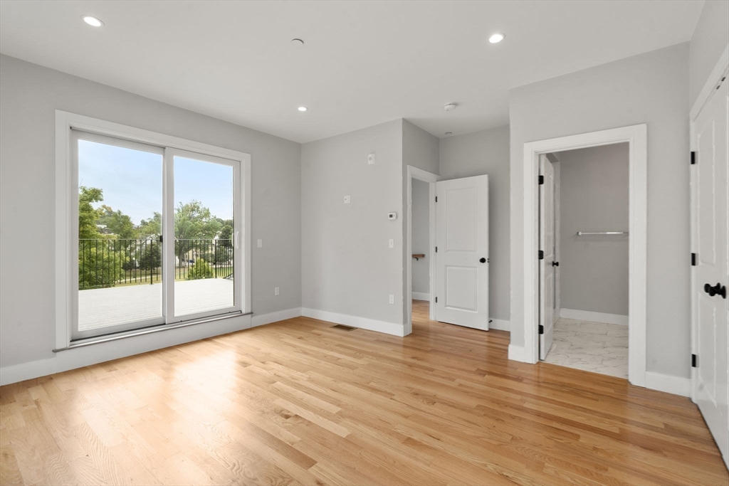 123-125 Centre Street, Unit TH7 Boston, MA 02124 - Photo 12 of 37 a view of an empty room with wooden floor and a window