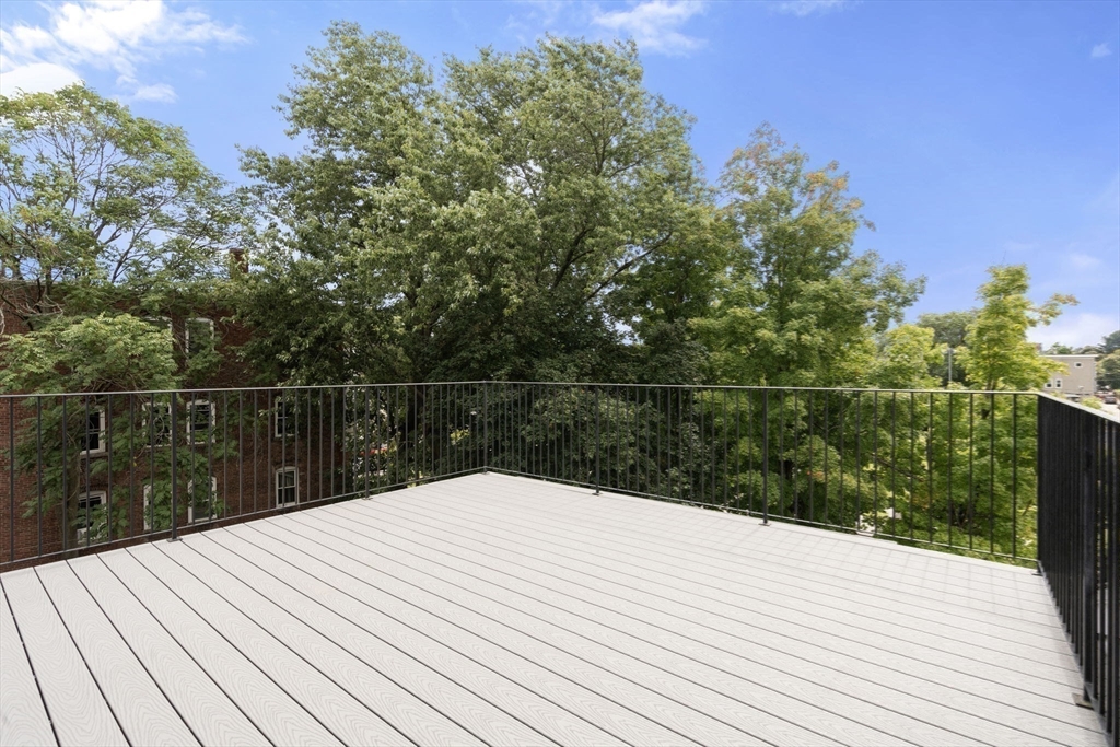 123-125 Centre Street, Unit TH7 Boston, MA 02124 - Photo 14 of 37 a wooden floor on top of a wooden deck
