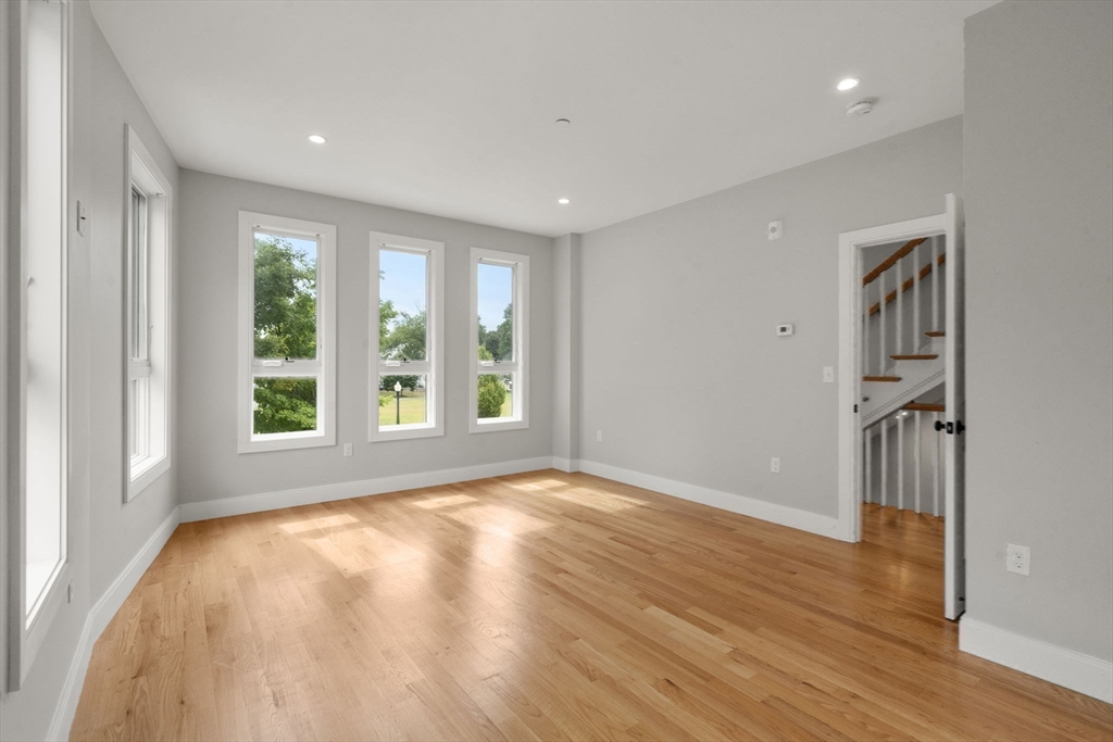 123-125 Centre Street, Unit TH7 Boston, MA 02124 - Photo 19 of 37 a view of an empty room with wooden floor and a window
