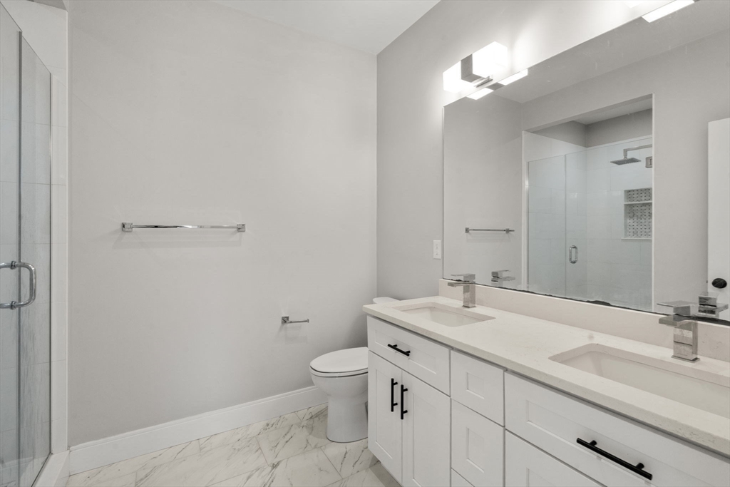 123-125 Centre Street, Unit TH7 Boston, MA 02124 - Photo 23 of 37 a bathroom with a toilet a sink and mirror