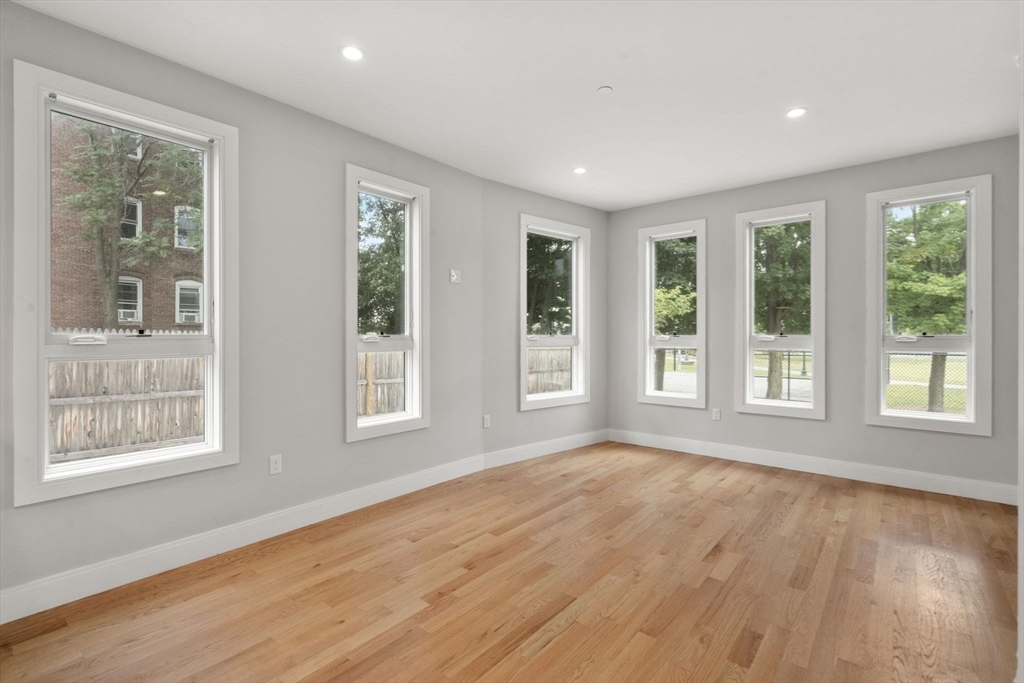123-125 Centre Street, Unit TH7 Boston, MA 02124 - Photo 5 of 37 a view of an empty room with a window and wooden floor