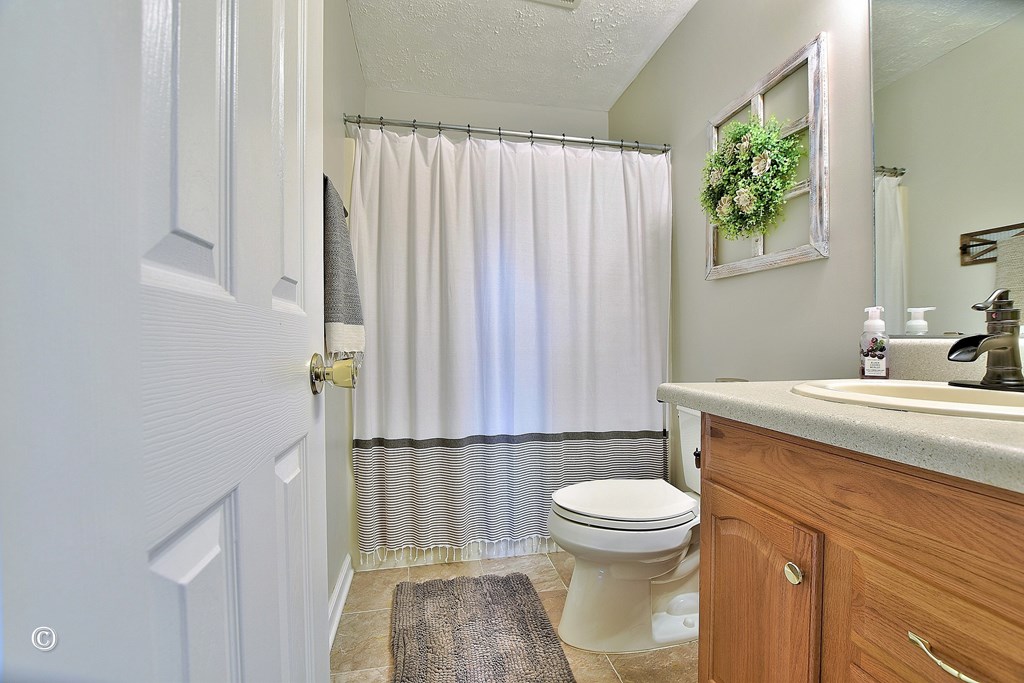 4968 Daybreak Lane Columbus, GA 31909 - Photo 15 of 24 a bathroom with a sink a toilet and shower curtain