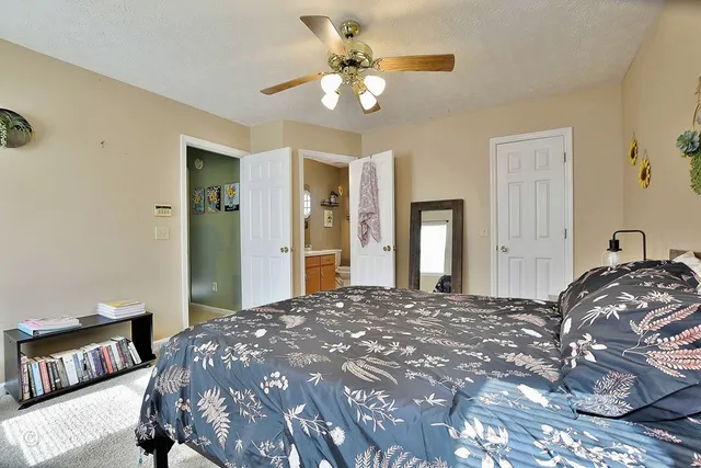 a bedroom with a large bed and a chandelier
