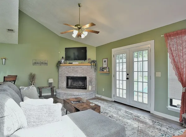 a living room with furniture a fireplace and a flat screen tv