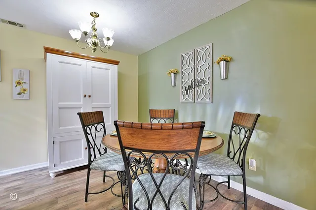 a view of a dining room with furniture and chandelier