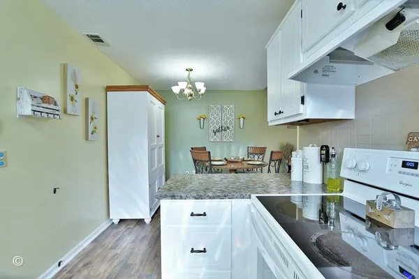a kitchen with stainless steel appliances granite countertop a sink a stove and a wooden floors