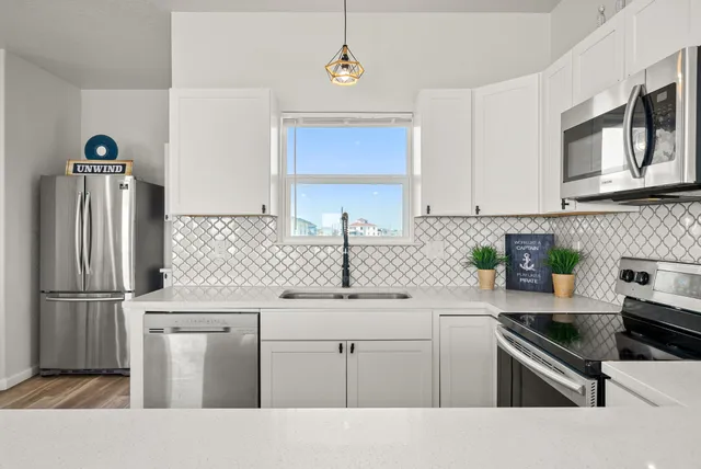 a kitchen with stainless steel appliances granite countertop a sink stove and refrigerator
