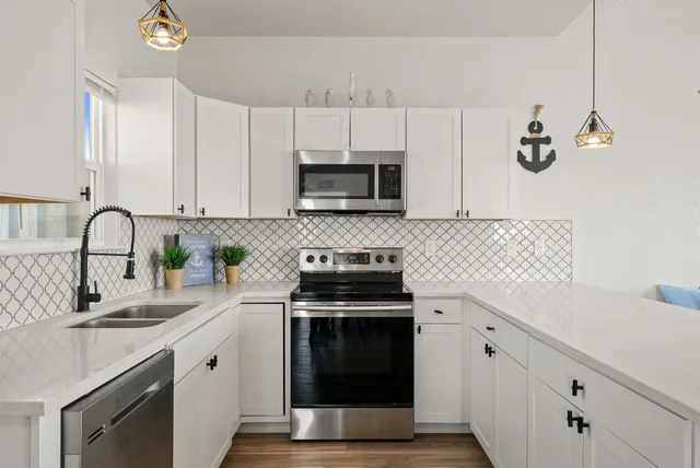 a kitchen with granite countertop a stove sink and cabinets