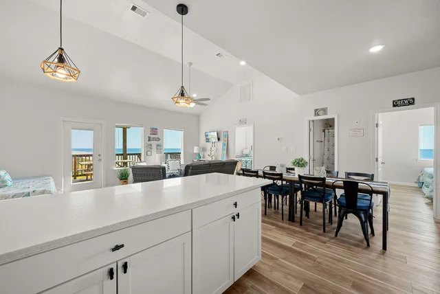 a very nice looking dining room with a large center island a dining table and chairs