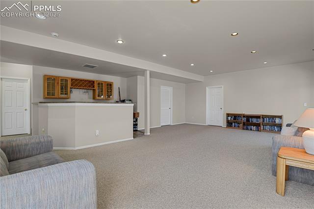 12237 Rio Secco Road Peyton, CO 80831 - Photo 31 of 45 Carpeted living room with bar area