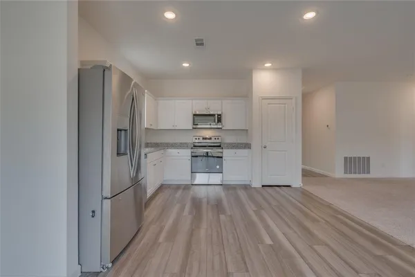 a kitchen with white cabinets and stainless steel appliances