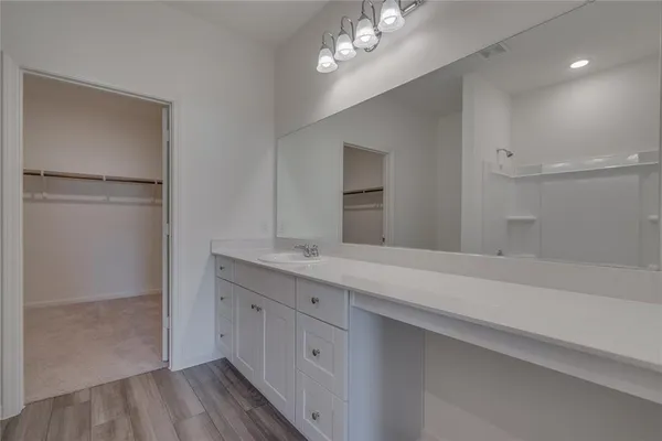a spacious bathroom with a granite countertop sink a mirror and a shower