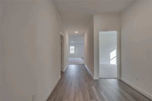 a view of a hallway with wooden floor
