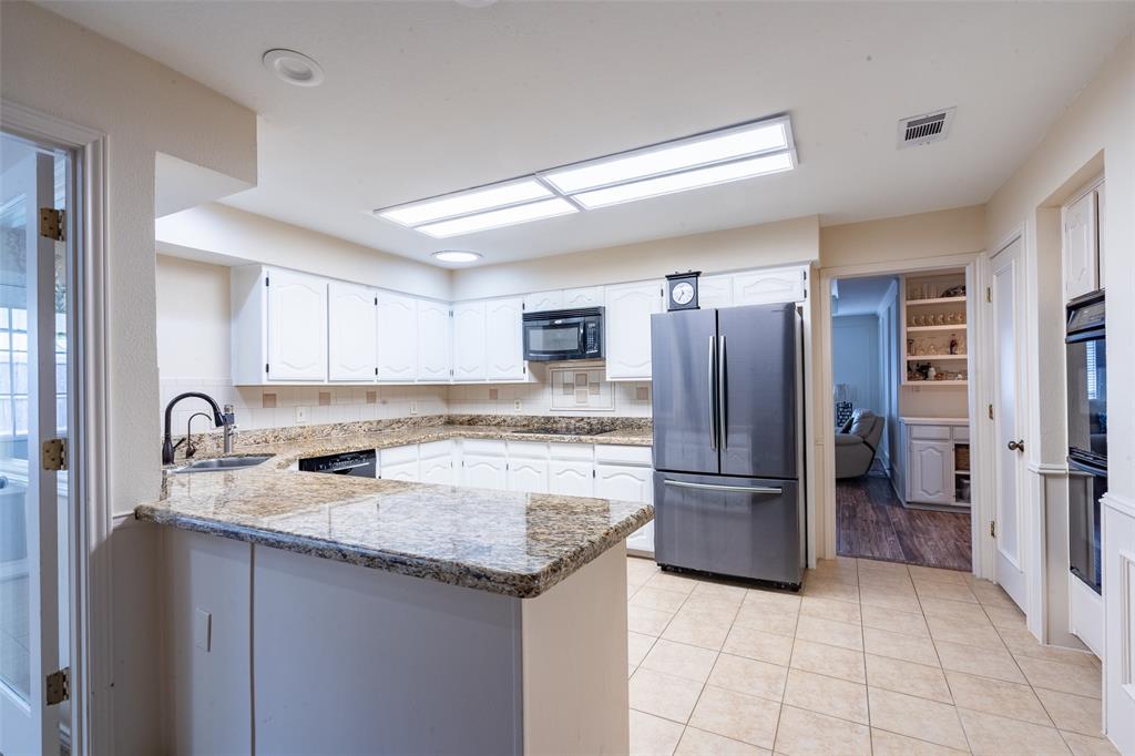 3905 Cross Bend Road Plano, TX 75023 - Photo 19 of 27 a kitchen with a refrigerator sink and cabinets
