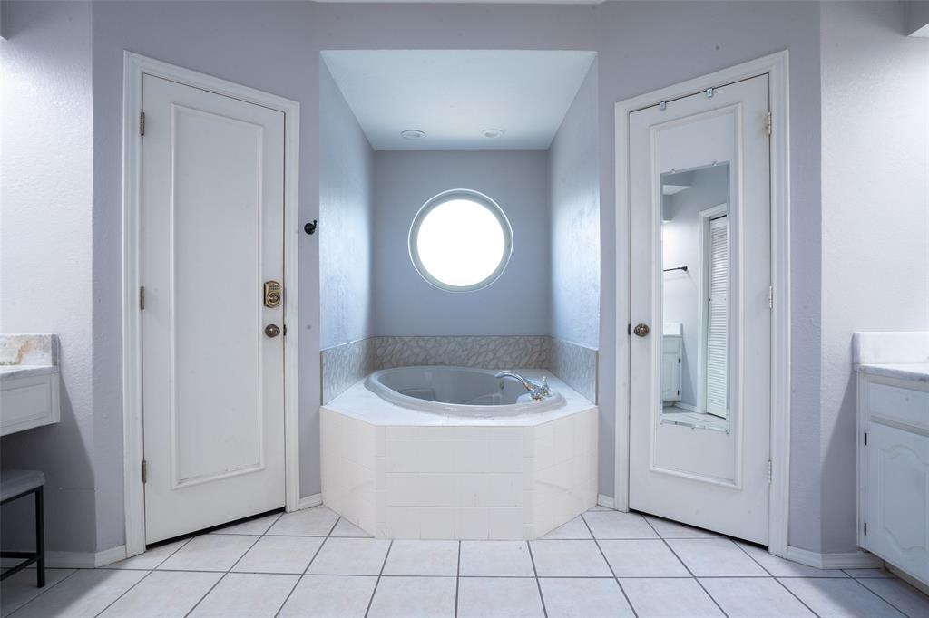 3905 Cross Bend Road Plano, TX 75023 - Photo 21 of 27 a bathroom with a toilet a sink a mirror and bathtub