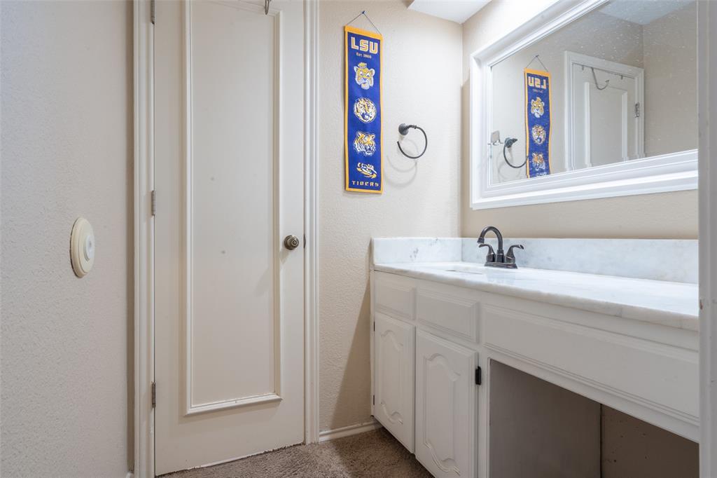 3905 Cross Bend Road Plano, TX 75023 - Photo 7 of 27 a bathroom with a sink and a mirror