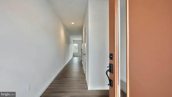 a view of a hallway with wooden floor