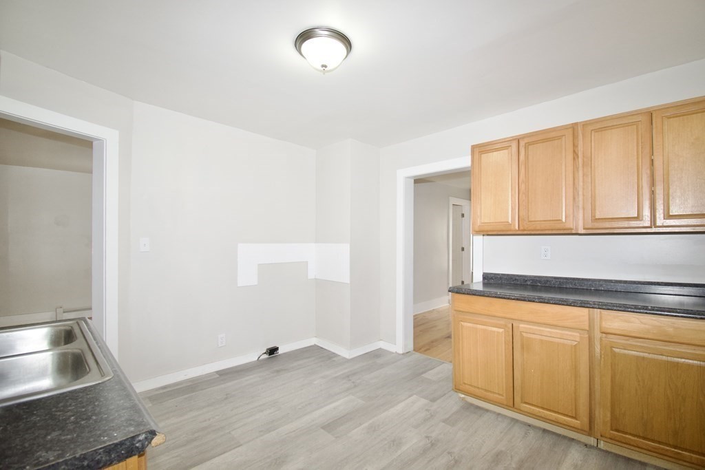 38 Collins Street Springfield, MA 01109 - Photo 11 of 39 a view of a kitchen with wooden floor and electronic appliances
