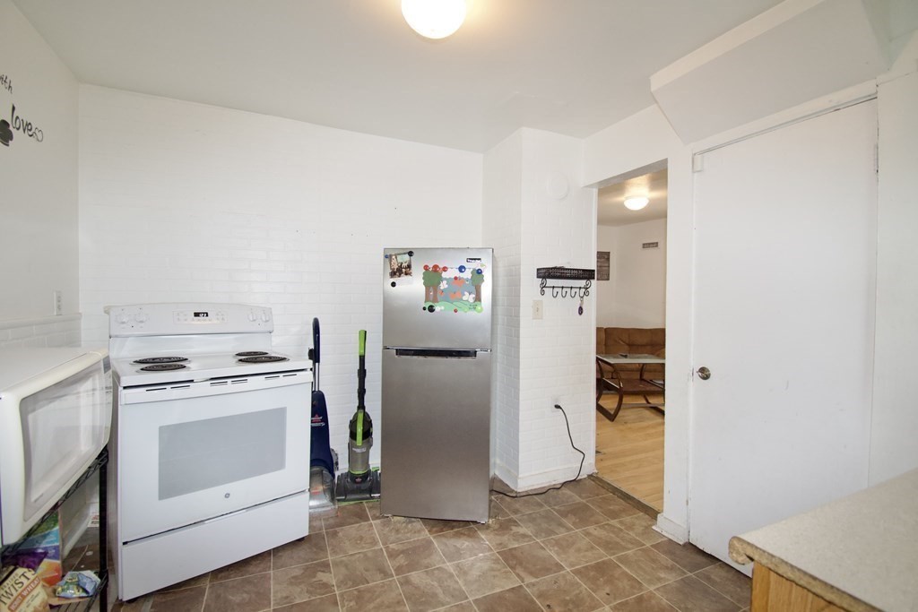 38 Collins Street Springfield, MA 01109 - Photo 24 of 39 a kitchen with a stove top oven and refrigerator