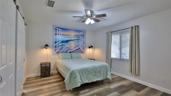 a bedroom with a large bed and a chandelier