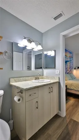 a bathroom with a granite countertop sink mirror and toilet