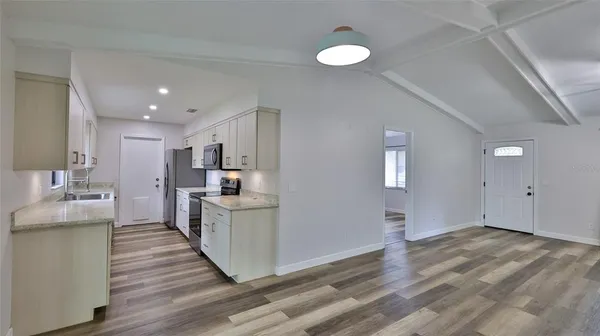 a kitchen with white cabinets and stainless steel appliances
