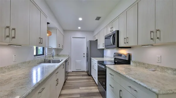 a kitchen with stainless steel appliances granite countertop a sink stove and refrigerator