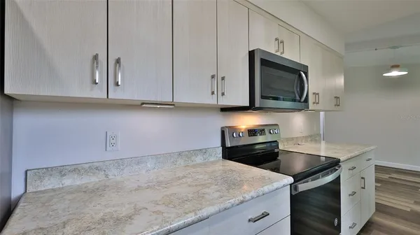 a kitchen with granite countertop cabinets stainless steel appliances and a sink