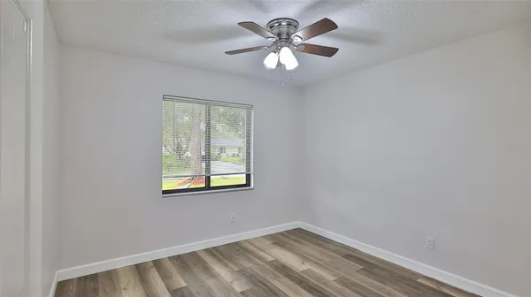 a view of a big room with wooden floor and windows