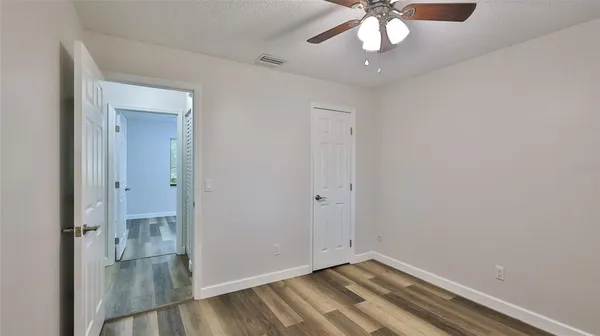 an empty room with chandelier fan