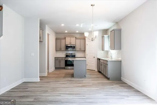 a kitchen with granite countertop white cabinets and stainless steel appliances