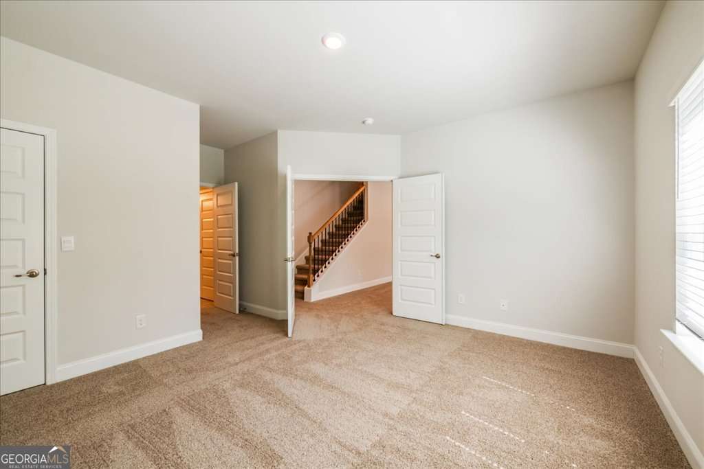 219 Carsons Walk Macon, GA 31206 - Photo 49 of 57 an empty room with a staircase and a ceiling fan