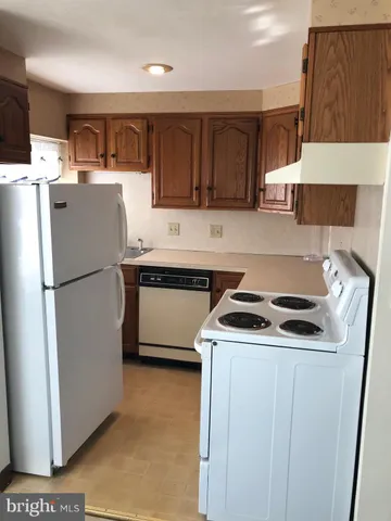 a kitchen with kitchen island a sink a stove and refrigerator