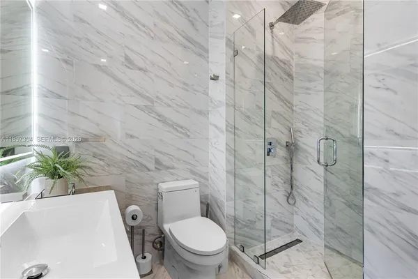 a bathroom with a shower a toilet and sink