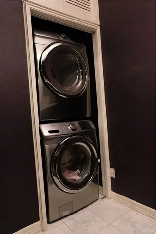 a kitchen with granite countertop white cabinets stainless steel appliances a sink and a window