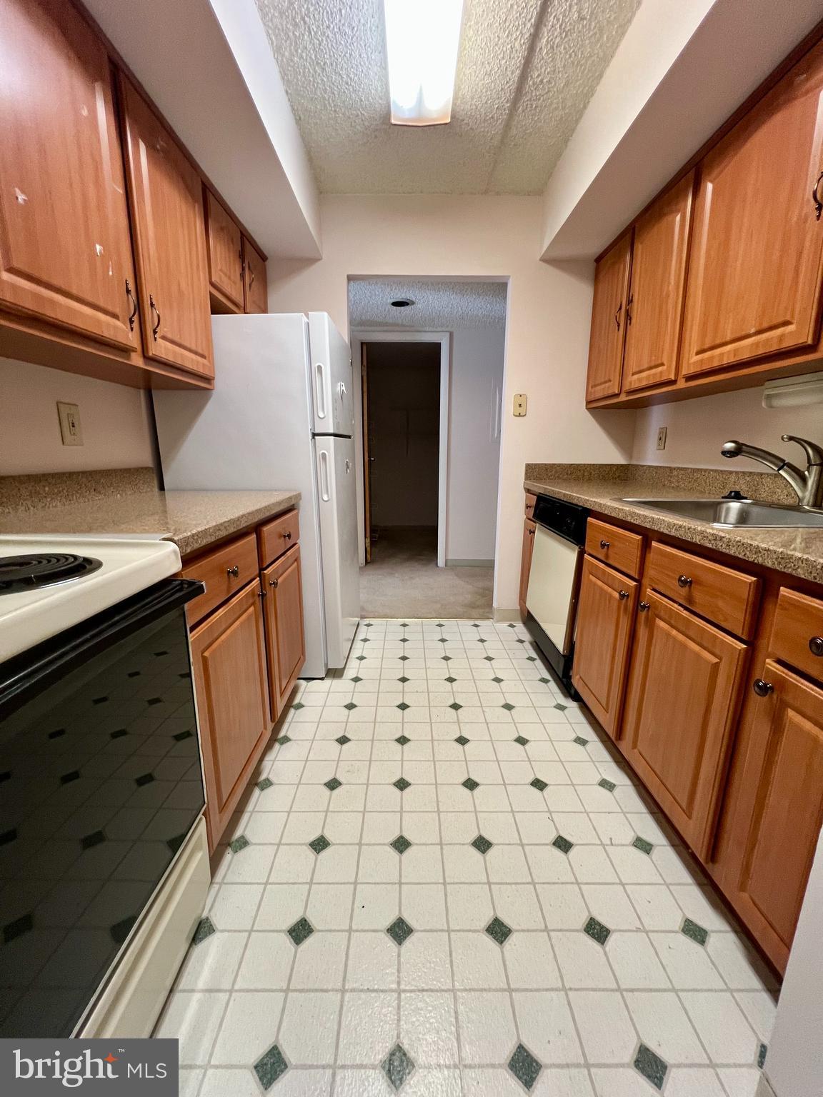 a kitchen with granite countertop a stove a sink and dishwasher