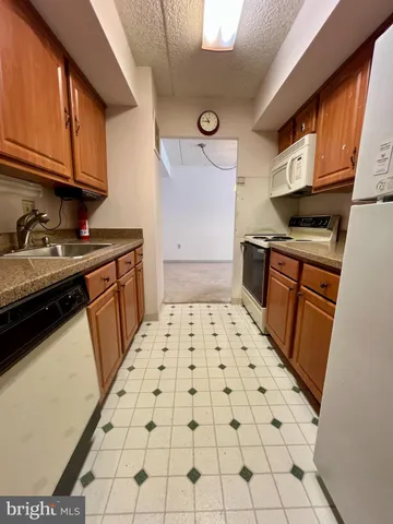 a kitchen with granite countertop a stove a sink and a microwave