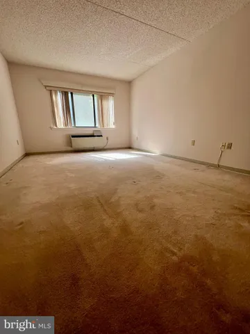 an empty room with cabinet and mirror