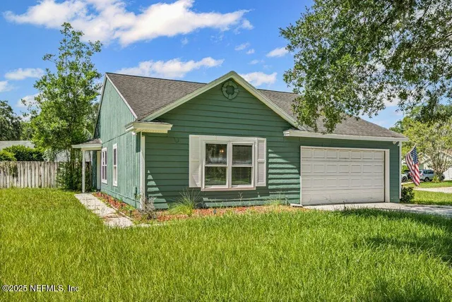 a front view of house with yard and green space