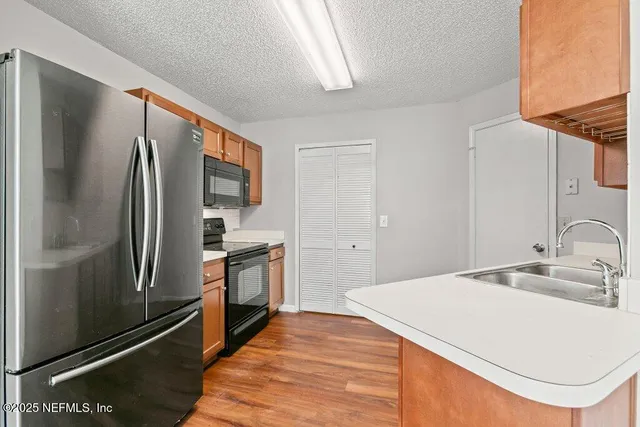 a kitchen with stainless steel appliances a refrigerator sink and stove