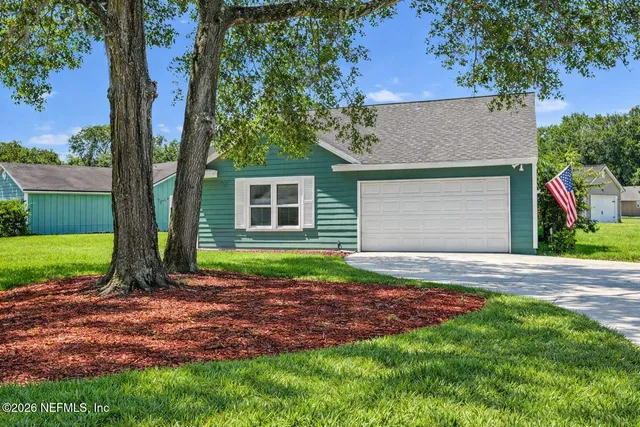 a view of a house with a yard and garage