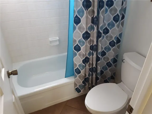 a white toilet sitting next to a bath tub