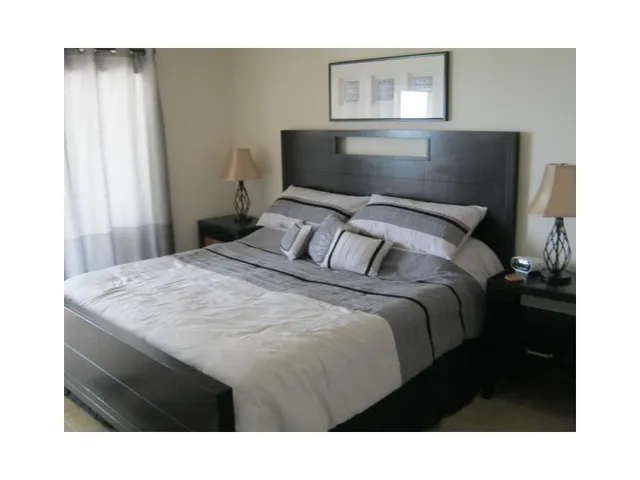 a bedroom with a bed and a painting on the wall