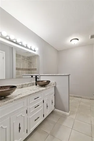 a spacious bathroom with a granite countertop sink a mirror and a