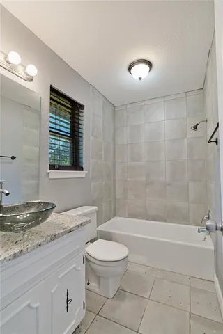 a bathroom with a granite countertop toilet a sink and bathtub