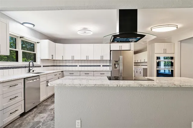 a kitchen with stainless steel appliances granite countertop a stove a sink and a refrigerator