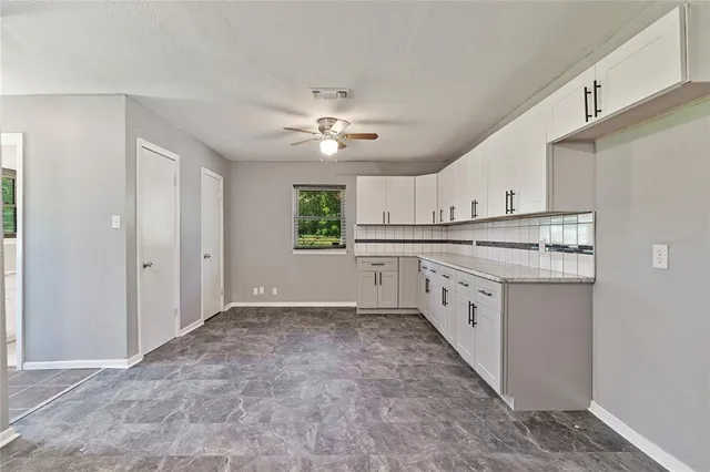a kitchen with granite countertop a sink stove cabinets and refrigerator